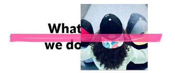 Trois enfants, une fille et deux garçons, vus de dos assis dans un skatepark, portant des casquettes cool style streetwear avec visière plate, rouge et noire, noire avec motif imprimé tropical, grise avec visière jaune, message "what we do" et scotch rose fluo décoratif sur la photo