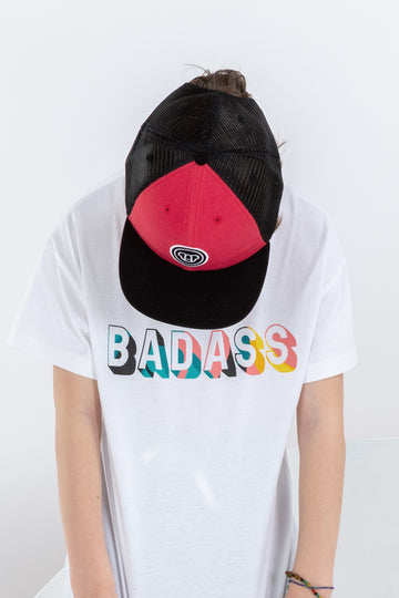 garçon de 8 ans look streetwear cool portant une casquette réglable à visière plate en coton, rouge et noire, et un t-shirt blanc unisexe pour enfants coupe oversize, en coton bio, imprimé Badass coloré