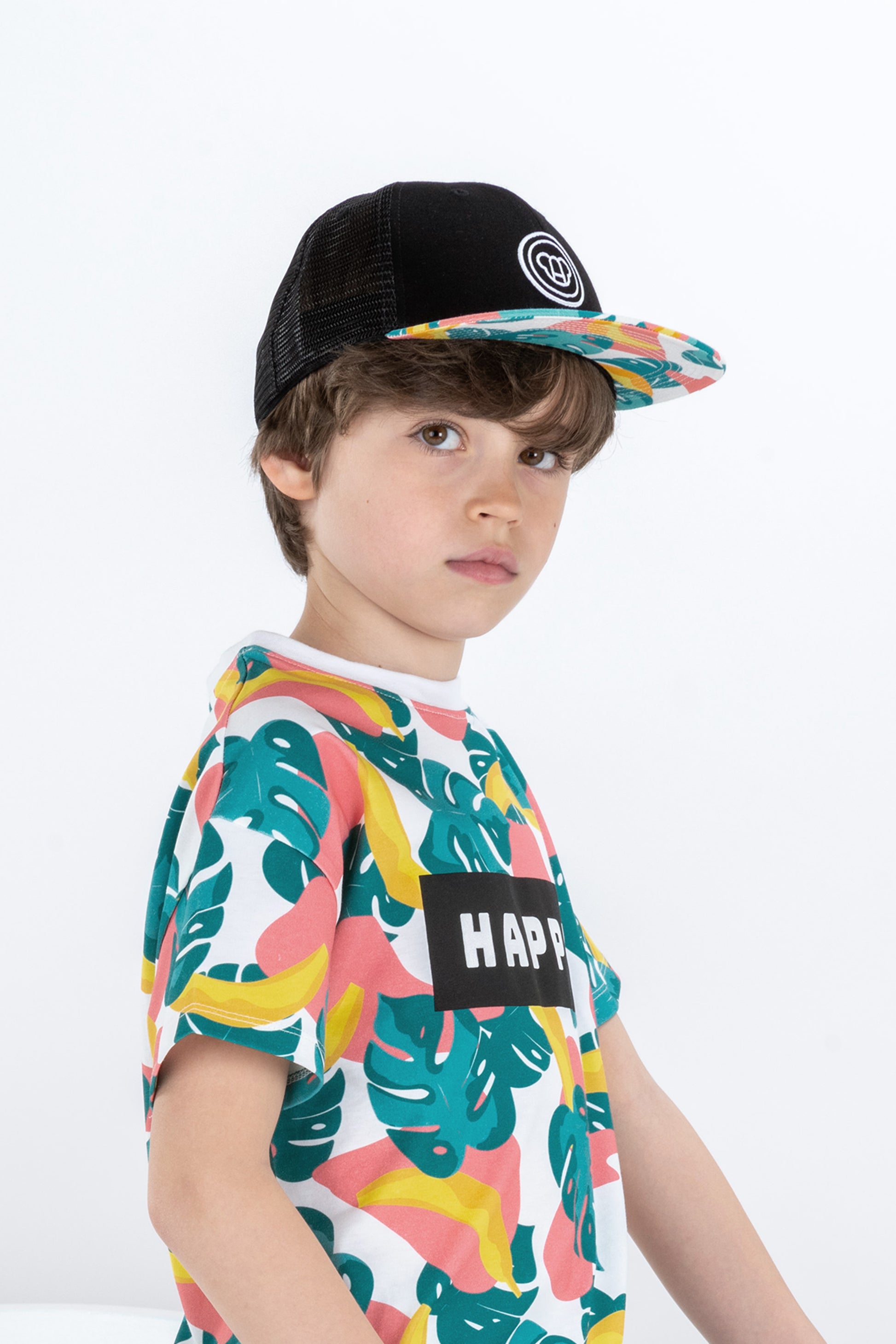 garçon de 8 ans look streetwear skate avec t-shirt large en coton bio motif tropical coloré Happy et casquette noire réglable pour enfant avec visière plate, motif cool tropical, logo ours Allmemberz brodé