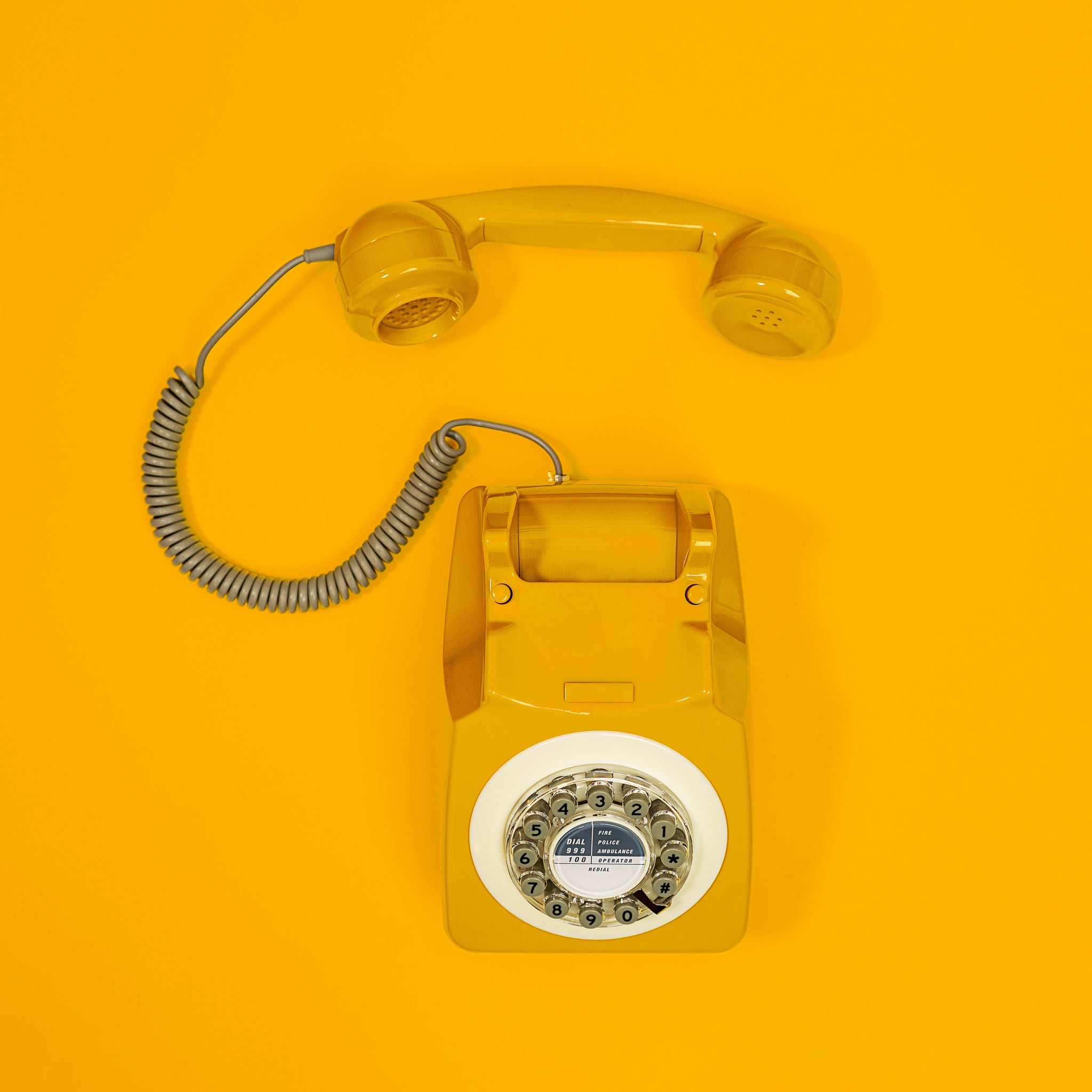 téléphone rétro vintage jaune moutarde fond monochrome