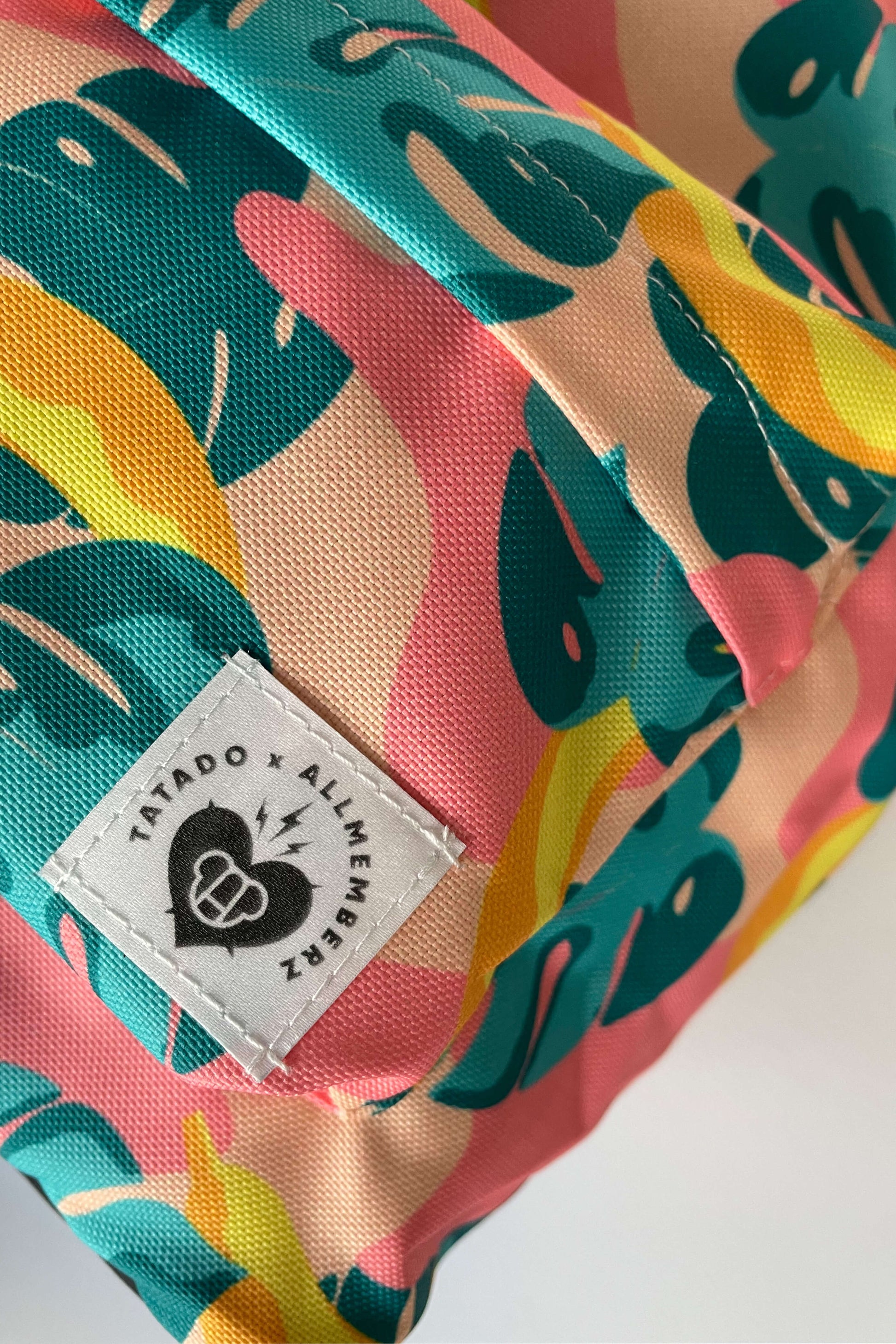 sac à dos pour enfant motif imprimé tropical joyeux et coloré, feuilles et bananes, vue en gros plan, poche devant, toile résistante imperméable