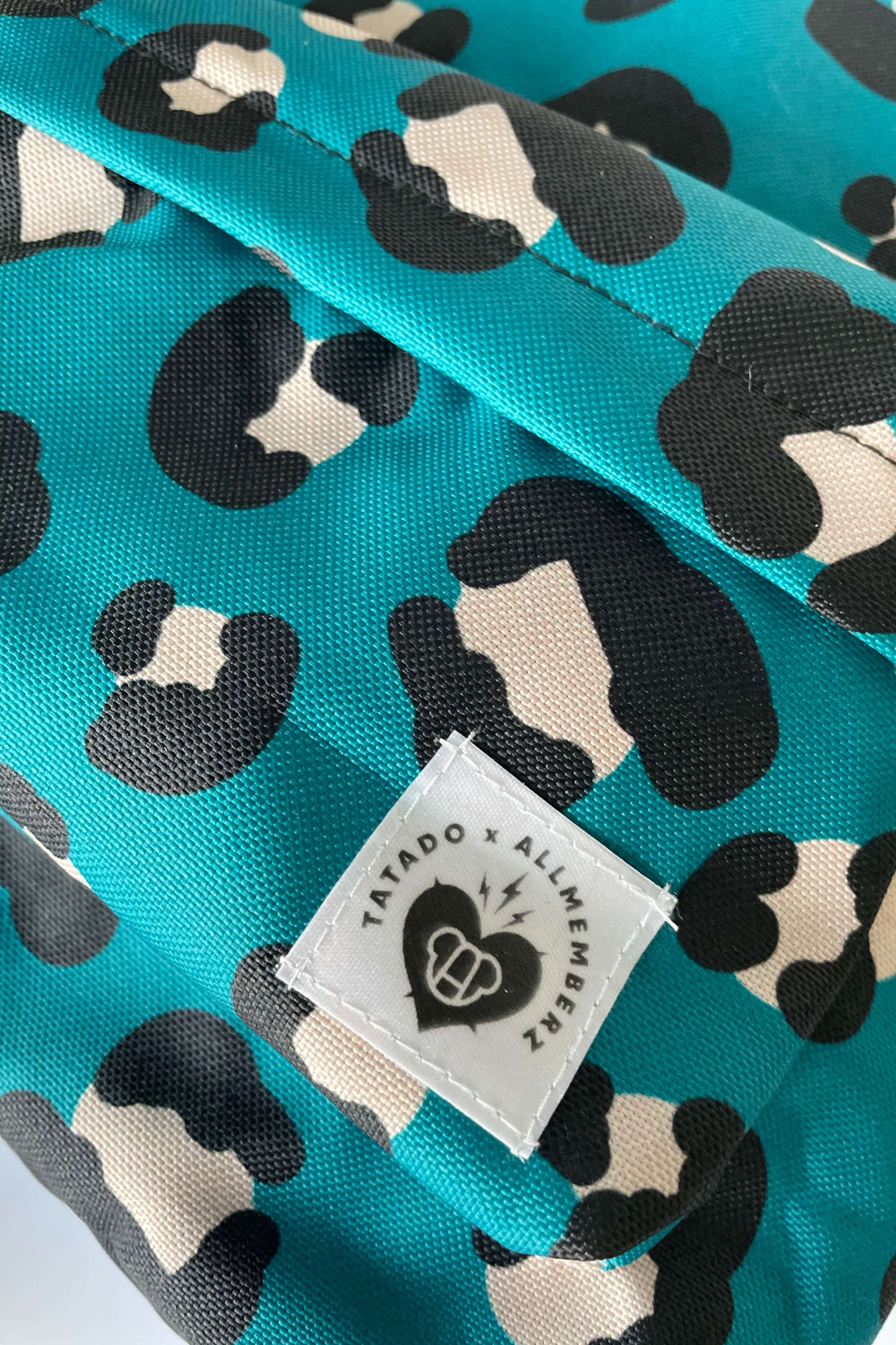 sac à dos pour enfant motif imprimé léopard fond bleu vert, vue en gros plan, poche devant, toile résistante imperméable