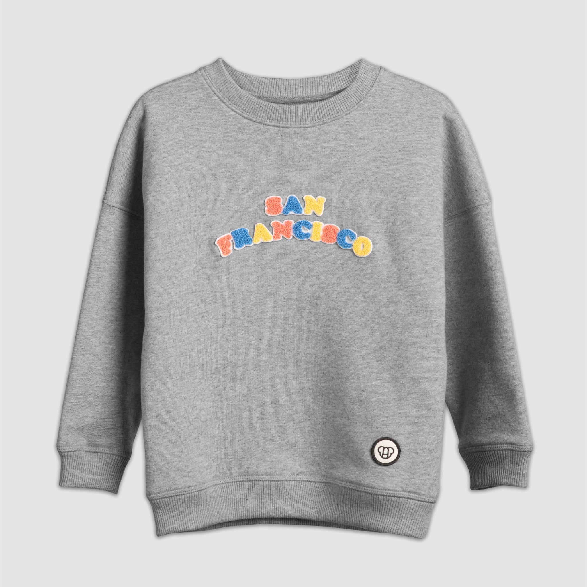 Look streetwear cool, sweat pour enfants coupe oversize gris chiné en coton bio motif lettrage San Francisco multicolore patch chenille