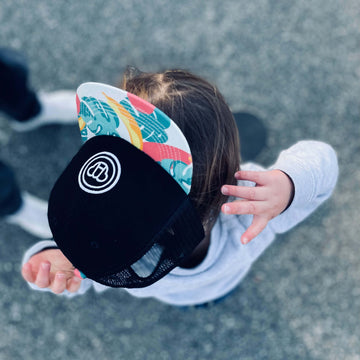 garçon de 2 ans style cool kid portant une casquette noire réglable pour enfant avec visière plate, motif tropical, logo ours Allmemberz brodé